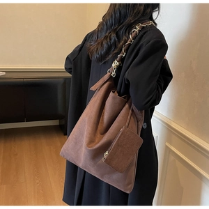 Vue détaillée du sac hobo en daim marron avec bandoulière chaîne dorée et pochette