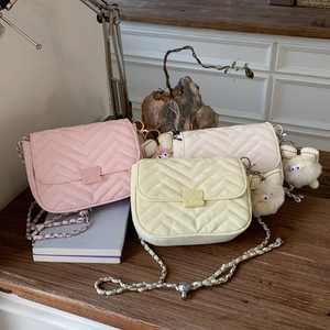 Detailansicht gesteppter Kettenhandtaschen in Pastellfarben mit Plüsch-Taschenanhängern