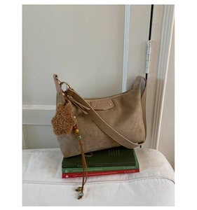 Détail du sac à bandoulière en daim kaki avec breloque étoile et glands perlés colorés