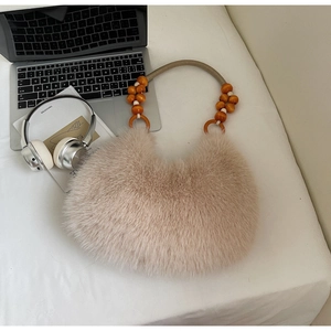 Detailed close-up of a fuzzy faux fur beige handbag with beaded handle and woven cord