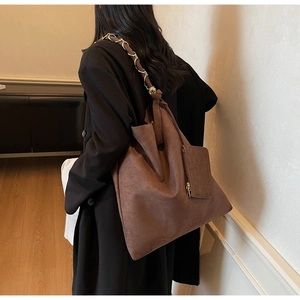 Détail du grand sac cabas marron mat avec bandoulière chaîne et pochette assortie