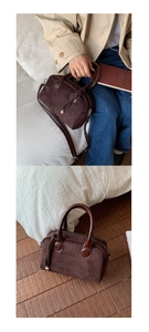 Detail of dark brown suede Boston bag with leather handles and metallic heart charm