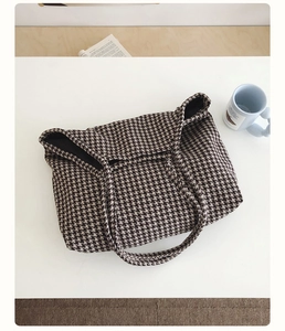 Top-down view of large houndstooth tote bag with canvas texture on a white table