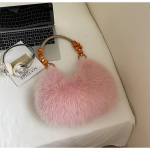 Detailed texture of pink faux fur crescent bag featuring natural wooden bead handle