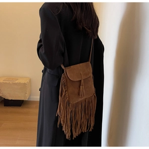 Détail du sac à bandoulière en daim marron bohème avec de longues franges et un gland