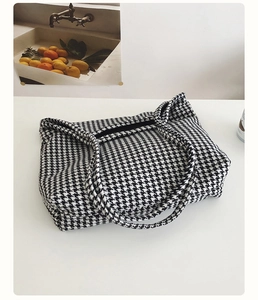 Detailed close-up of classic black and white houndstooth fabric on a flat tote bag