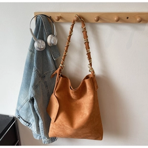 Détail du sac fourre-tout en daim caramel avec chaîne dorée et mini pochette pendante