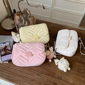 Detailansicht von drei V-gesteppten Taschen mit Keks-Verschluss und Plüschmonster-Anhängern