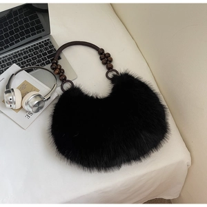 Close-up of black fluffy faux fur bag featuring a woven strap with wooden bead accents
