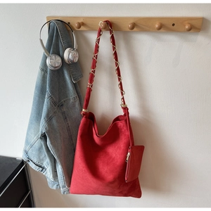 Détail du sac cabas en daim rouge avec bandoulière en chaîne et petite pochette zippée