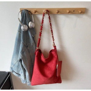 Détail du sac Hobo en daim rouge avec bandoulière chaîne dorée et petit porte-monnaie
