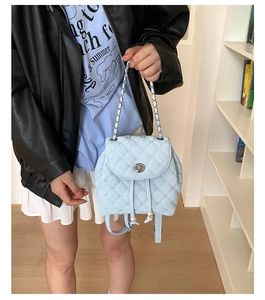 Dettaglio dello zaino trapuntato azzurro con coulisse di perle e chiusura a girello