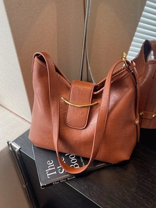 Classic amber brown hobo shoulder bag with a curved gold metal hardware ornament