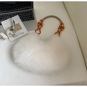 White faux fur handbag with wooden beads strap on minimalist desk with laptop