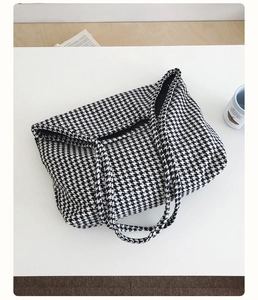 Close-up of black and white houndstooth canvas tote bag with dual shoulder straps