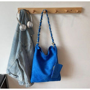 Détail d'un sac hobo bleu roi en suédine avec bandoulière chaîne et mini pochette