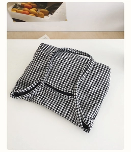 Detailed close-up of classic black and white houndstooth fabric on a spacious tote bag
