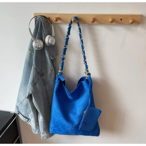 Détail du sac fourre-tout bleu roi en daim avec bandoulière chaîne et petit porte-monnaie