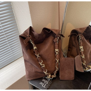 Vue détaillée du sac hobo en daim marron avec chaîne dorée et petite pochette assortie