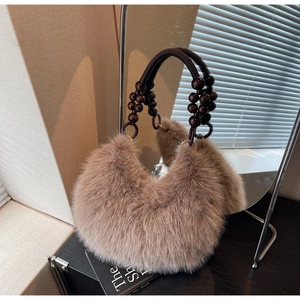 Close-up of brown faux fur handbag featuring unique dark brown beaded handle and metal rings