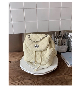 Dettaglio zaino trapuntato beige con coulisse di perle e chiusura a girello argento