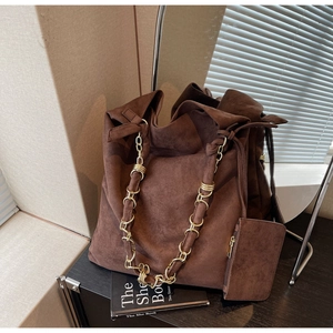 Détail du sac cabas en daim marron foncé avec chaîne dorée et petite pochette latérale
