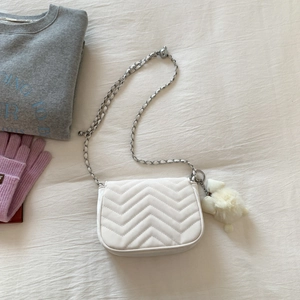 Weiße Stepptasche mit V-Nähten und einem niedlichen Plüschschaf-Anhänger im Detail