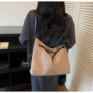 Detail of soft leopard print tote bag featuring black leather trim and gold buckle closure
