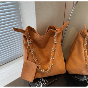 Détail du sac cabas en daim caramel avec chaîne dorée et pochette assortie incluse
