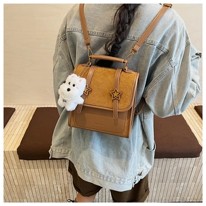 Detail of vintage brown quilted backpack with star charm and plush dog keychain