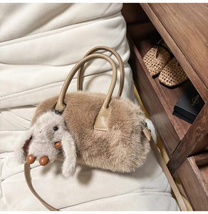 Detail of plush fuzzy handbag with leather strap and cute long-eared bunny charm