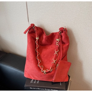 Vue détaillée du grand sac cabas en daim rouge avec chaîne et pochette assortie