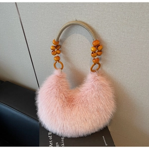 Detailed close-up of pink fluffy plush handbag with decorative orange beaded handle