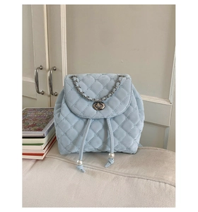 Dettaglio zaino trapuntato azzurro con chiusura a catena e coulisse con perle raffinate