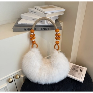 Detailed shot of white faux fur handbag with stylish orange wooden beads and woven handle