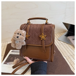 Detail of brown vintage backpack featuring star buckles and quilted diamond pattern cover