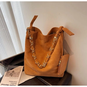 Détail du sac cabas en daim caramel avec chaîne dorée et texture en cuir souple
