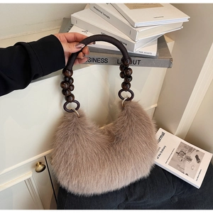Close-up of hobo bag with fluffy fur, dark woven handle, and brown wooden beads