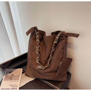Détail d'un grand cabas en daim marron avec chaîne dorée et sa petite pochette assortie