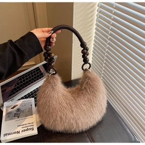 Detail of camel faux fur bag featuring a unique dark wooden bead and braided rope handle