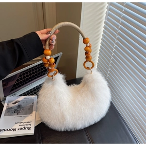 Detail view of white faux fur handbag with orange wooden bead woven handle and gold hardware