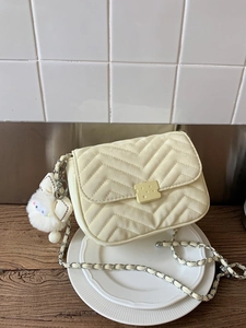 Gelbe Stepptasche mit V-Nähten, Kettenriemen und originellem Keks-Metallverschluss