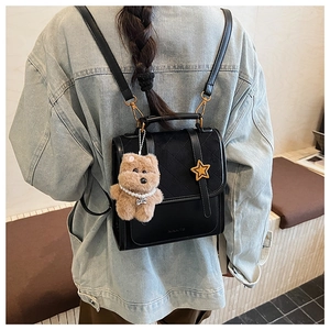 Model view of black quilted mini backpack with teddy bear and pearl chain charms