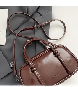 Detail of dark brown wax leather bowling bag with CLEAROK branding and slim strap