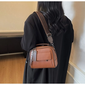 Detailed back view of a brown lychee pattern leather crossbody bag with a wide strap