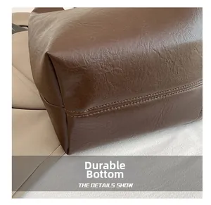 Detailed macro view of the wear-resistant dark brown leather tote bag bottom with litchi texture