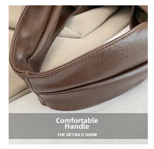 Close-up of soft dark brown leather tote bag with thick stitching and lychee grain texture
