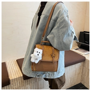 Detail der braunen Vintage-Patchworktasche mit Sternbeschlag und Plüsch-Anhänger