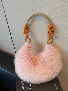 Pink faux fur half-moon handbag with a beaded handle shown in a lifestyle scene