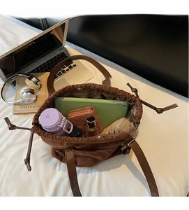Vista interior del bolso tote de ante marrón con capacidad para tablet y objetos varios